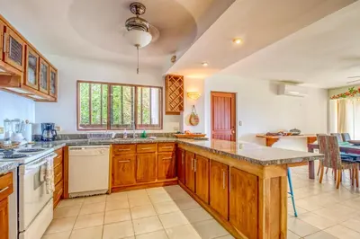 a large kitchen with wooden cabinets and a large island at Bahia Pez Vela Villa at 26 in Ocotal