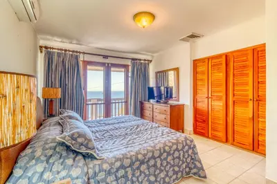 a bedroom with a bed and a dresser and a window at Bahia Pez Vela Villa at 26 in Ocotal