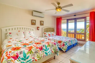 a bedroom with two beds and a balcony at Bahia Pez Vela Villa at 18 in Ocotal