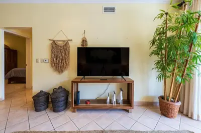 a living room with a flat screen tv on a stand at Sunrise 7 - 2 Bedroom, Ocean View Condo in Tamarindo
