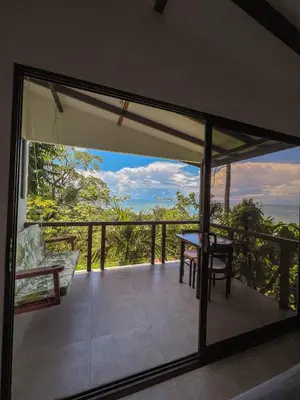 a balcony with a table and a view of the ocean at La Uvita Perdida in Uvita