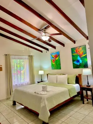 a bedroom with a large bed and a ceiling fan at Loma Real Hot Springs Bed & Breakfast in Fortuna