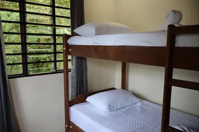 two bunk beds in a room with a window at Cabinas Las Chinitas in Zapotal