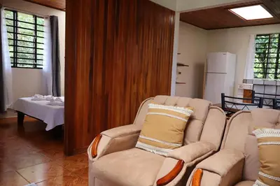 a living room with two chairs and a table at Cabinas Las Chinitas in Zapotal