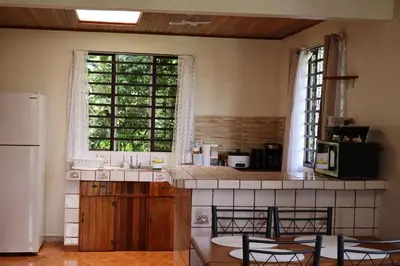 a kitchen with a sink and a large window at Cabinas Las Chinitas in Zapotal
