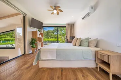a bedroom with a bed and a large window at Casa Nonos in Libertad