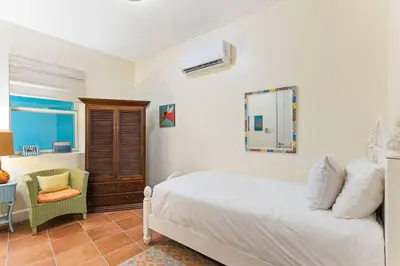 a bedroom with a bed and a chair and a mirror at Papagayo Villa w Ocean Views and 2 Private Pools in Nacascolo