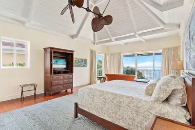 a bedroom with a bed and a television and windows at Papagayo Villa w Ocean Views and 2 Private Pools in Nacascolo