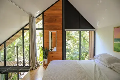 a bedroom with a large bed and large windows at D'Village 8 - 1 bdr loft in Mal País in Mal País