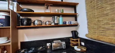 a kitchen with wooden shelves above a stove at Villa Don Juan in Rivas