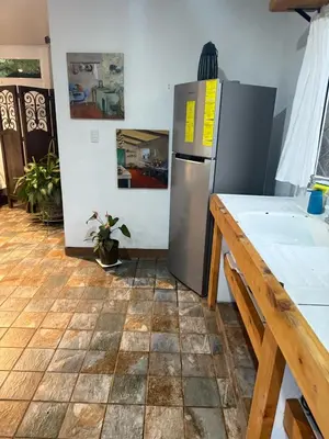 a kitchen with a refrigerator and a tile floor at Jicote finca de ecoturismo 1 in Paraíso