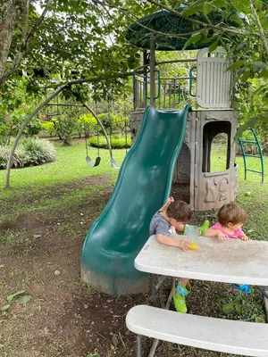 two children sitting on a bench next to a slide at Jicote finca de ecoturismo 1 in Paraíso
