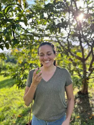 a woman is smiling while holding a green object at Jicote finca de ecoturismo 1 in Paraíso