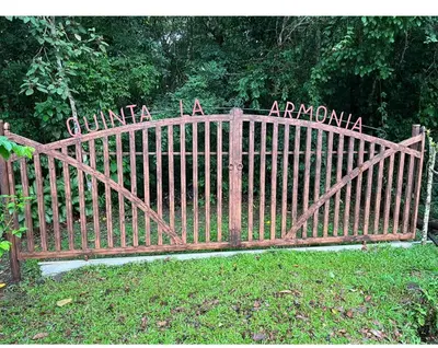 a wooden gate with a sign in the grass at Quinta de Montaña, San Carlos in Vara Blanca