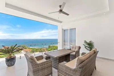 a living room with a table and chairs and the ocean at Luxury Oceanview Condo with Pool in Tamarindo