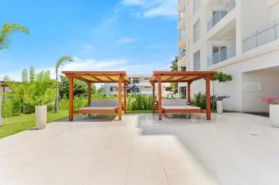 a gazebo with two benches in front of a building at Luxury Oceanview Condo with Pool in Tamarindo