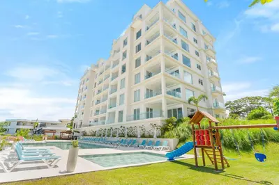 a large white building with a playground in front of it at Luxury Oceanview Condo with Pool in Tamarindo