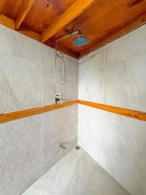 a bathroom with a shower with a wooden ceiling at Selva Partners Chachagua