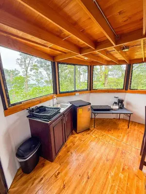 a kitchen with wooden floors and windows in a house at Selva Partners Chachagua