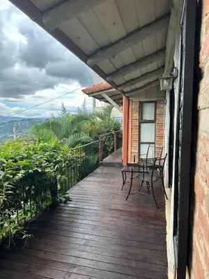 a wooden porch with chairs and a table on it at El Cabanon del Higuerón in Santa Ana