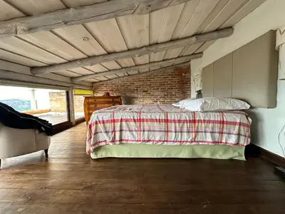 a bedroom with a bed and a brick wall at El Cabanon del Higuerón in Santa Ana