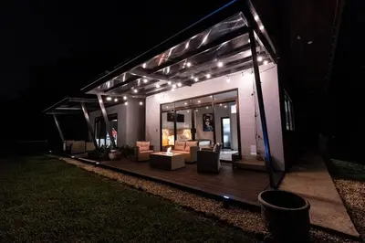 a house with a deck at night with lights at La Danta Lodge - Celeste River in Bijagua