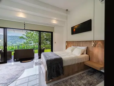 a bedroom with a bed and a large window at La Danta Lodge - Celeste River in Bijagua