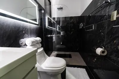 a black and white bathroom with a toilet and a sink at La Danta Lodge - Celeste River in Bijagua