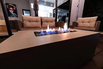 a fire pit in a living room with flames at La Danta Lodge - Celeste River in Bijagua