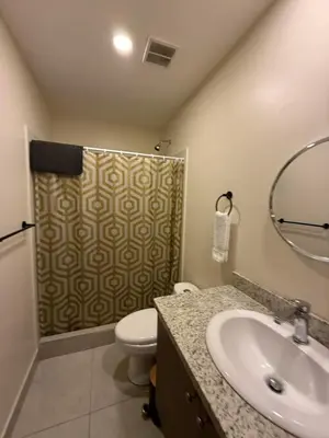 a bathroom with a toilet and a sink and a shower at Tropical Sunshine in Alajuela City