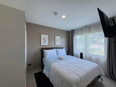 a bedroom with a large bed and a window at Tropical Sunshine in Alajuela City