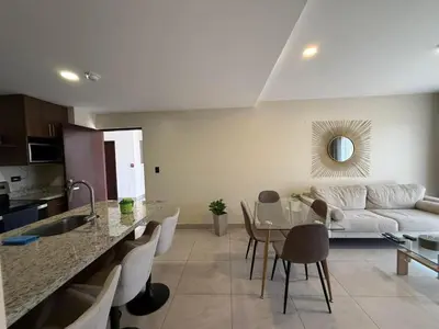 a kitchen and living room with a couch and a table at Tropical Sunshine in Alajuela City