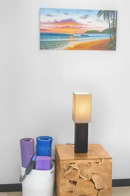 a table with a lamp on it next to a beach at Beachfront view large Condo with Pools PVT luxury patio in great location in Jacó