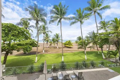 a view of a park with palm trees and chairs at Beachfront view large Condo with Pools PVT luxury patio in great location in Jacó