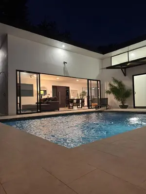 a swimming pool in front of a house at night at Casa Luna in Santa Cruz