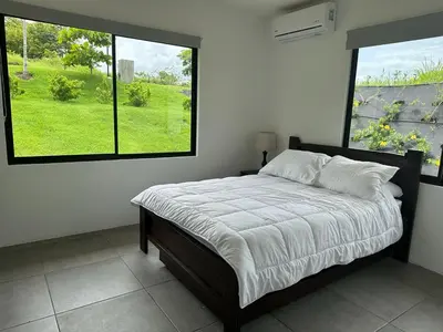 a bed in a bedroom with a large window at Casa Luna in Santa Cruz