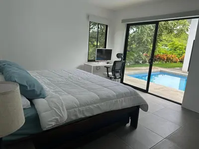 a bedroom with a bed and a desk and a pool at Casa Luna in Santa Cruz