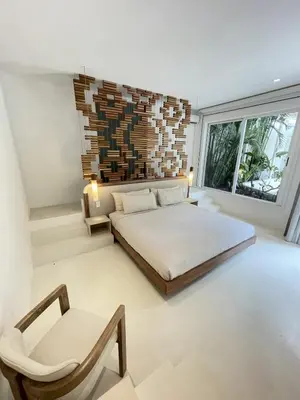 a bedroom with a king sized bed and a chair at Villa Bianca in Santa Teresa Beach