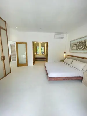 a white bedroom with a bed and a mirror at Villa Bianca in Santa Teresa Beach