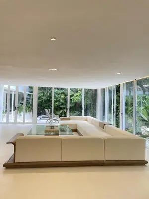 a large living room with a large couch and windows at Villa Bianca in Santa Teresa Beach