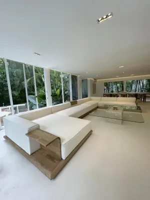 a large living room with a white couch and windows at Villa Bianca in Santa Teresa Beach