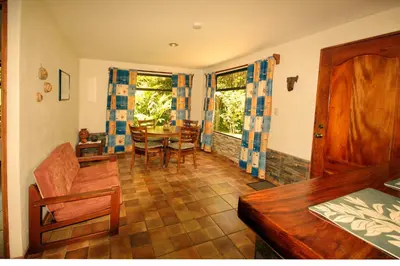 a living room with a table and a dining room at Casita Amapola in Tilarán