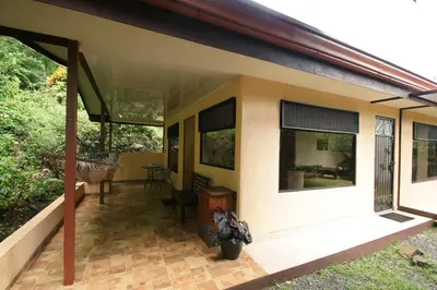 a small house with a porch and a patio at Casita Amapola in Tilarán