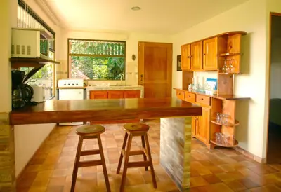 a kitchen with a counter and two stools at Casita Amapola in Tilarán