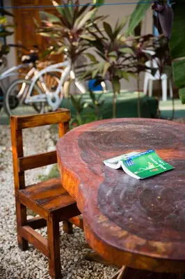 a wooden table with a chair next to a wooden table with a table at Aloha surf Nosara - Kahala Hui Cabanas #1 in Nosara