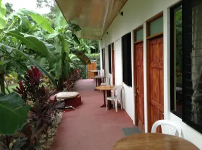 a porch of a house with tables and chairs at Aloha surf Nosara - Kahala Hui Cabanas #1 in Nosara