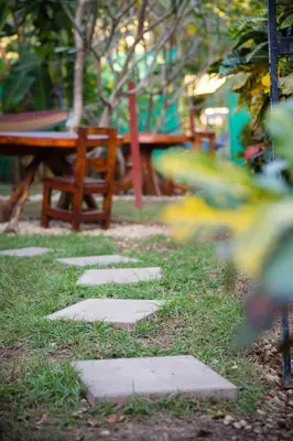 a stepping stone pathway in a park with a bench at Aloha Surf Nosara - Kahala Hui Cabins #2 in Nosara