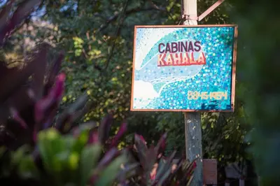 a sign for a caritas kaila on a pole at Aloha Surf Nosara - Kahala Hui Cabins #2 in Nosara