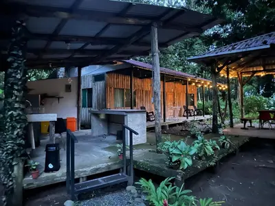 a house with a wooden roof and a patio at Almendros de Osa Lodge in Uvita