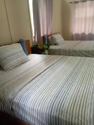 two beds sitting next to each other in a bedroom at Almendros de Osa Lodge in Uvita